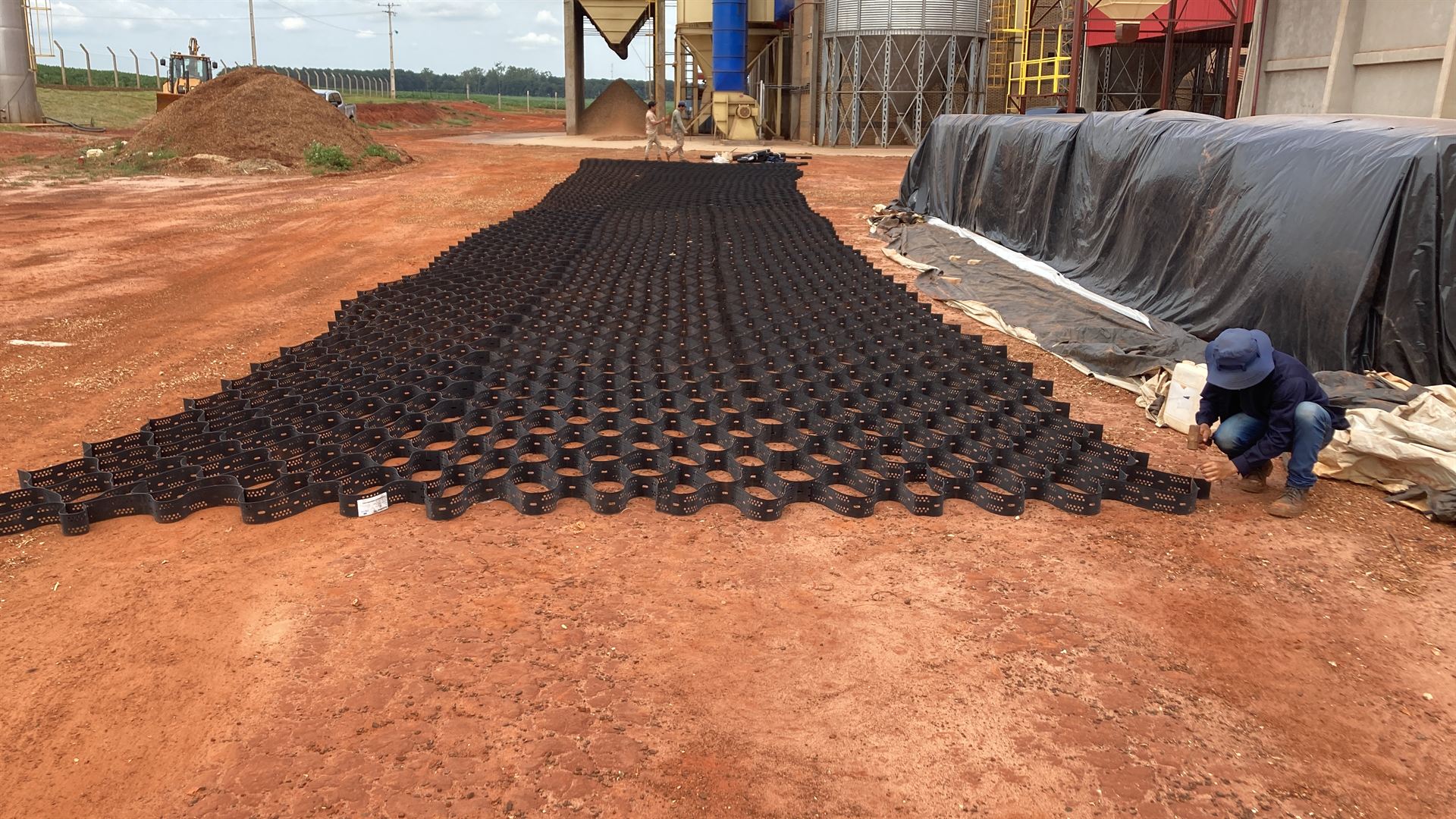 Geoceldas de confinamiento celular desplegadas en el patio de una planta industrial