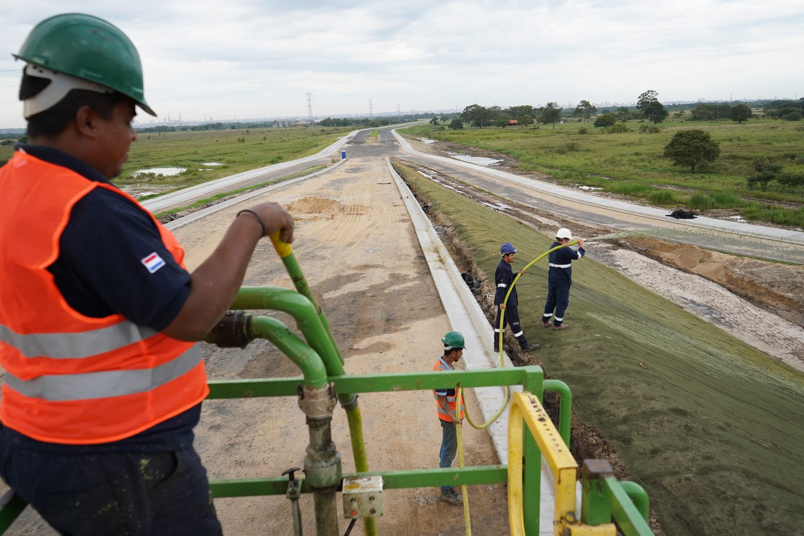 Operario sobre la hidrosembradora con el talud del viaducto ya tratado al fondo